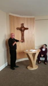 Fr. Column telling us about the cross in the Chapel - Sister Bridgetta looks on